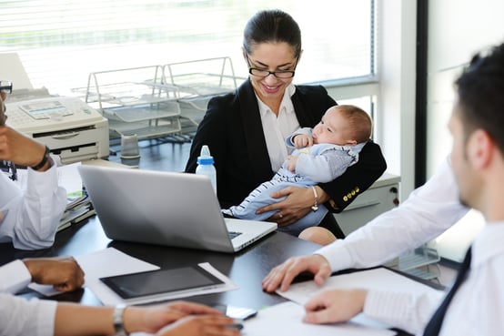 Business people taking care of baby in office