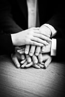 Image of business partners hands on top of each other symbolizing companionship and unity