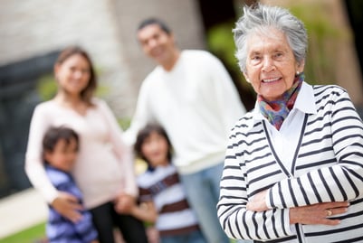 Lovely grandmother smiling with her family at the background