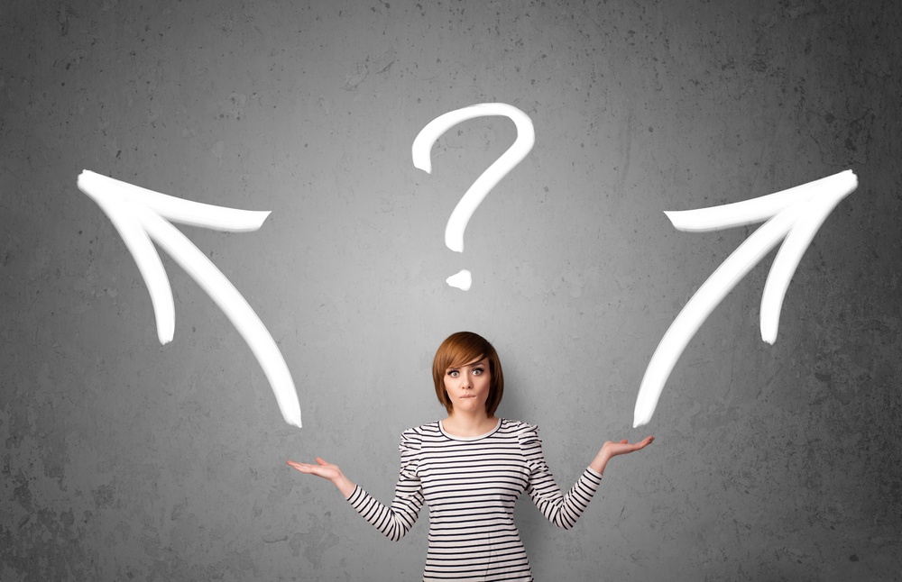 Pretty young woman making a decision with arrows and question mark above her head