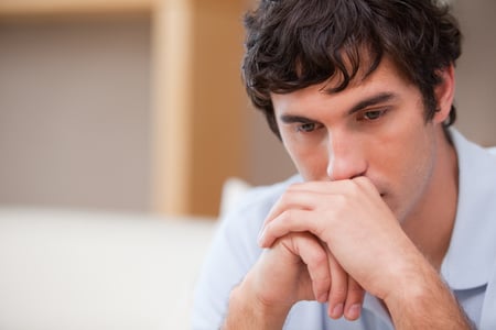 Thoughtful young man in the living room