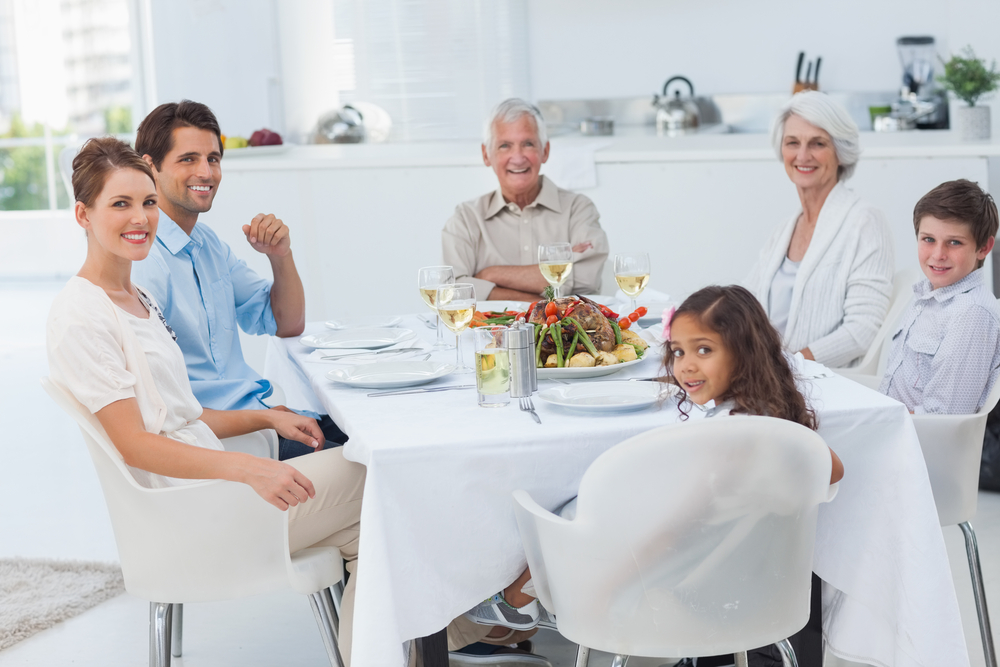 Family smiling at the dinner table and looking at camera-1