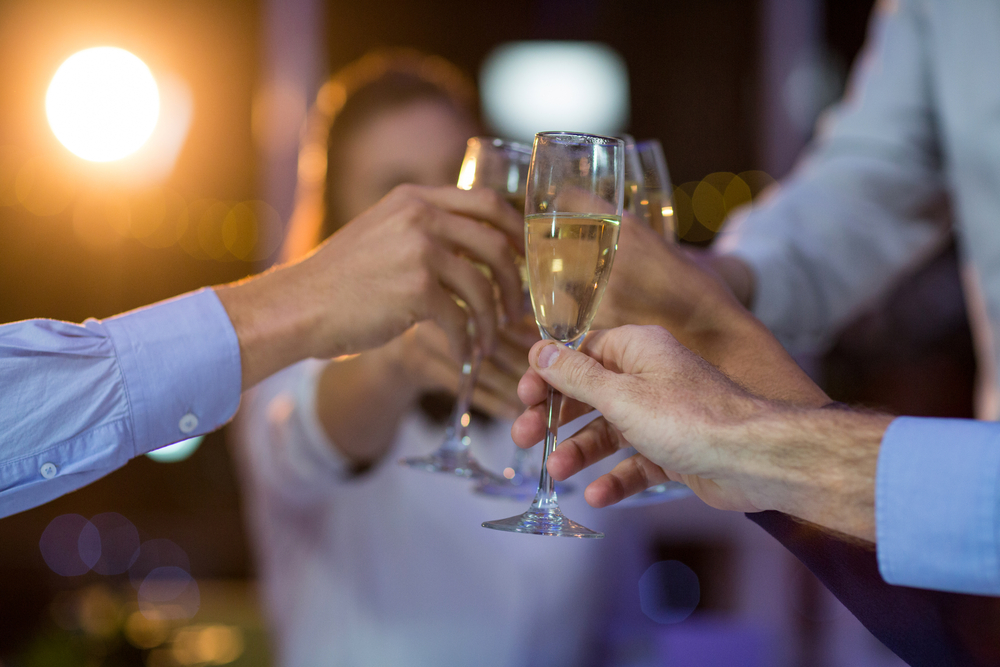 Group of businesspeople toasting glasses of champagne in office at night