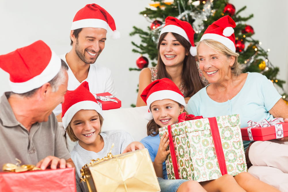 Happy family at christmas swapping gifts on the couch