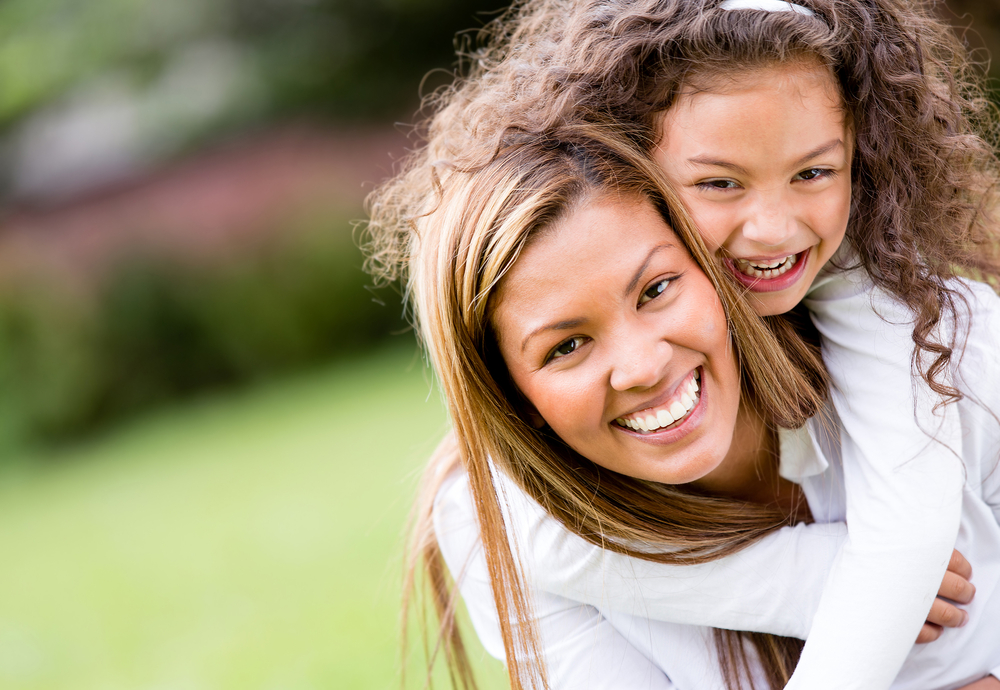 Happy mother and daughter laughing together outdoors