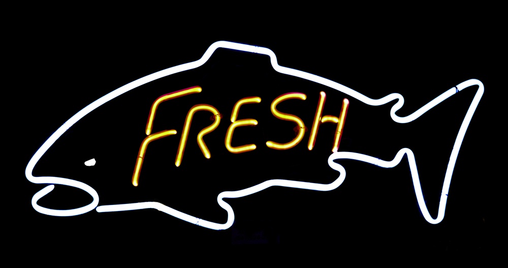 Neon sign in window of restaurant or shop that sells fresh fish