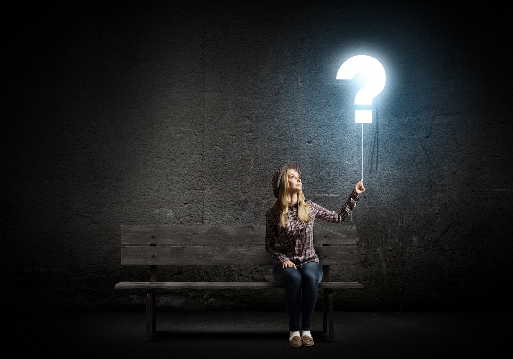 Young woman in casual holding balloon shaped like question mark